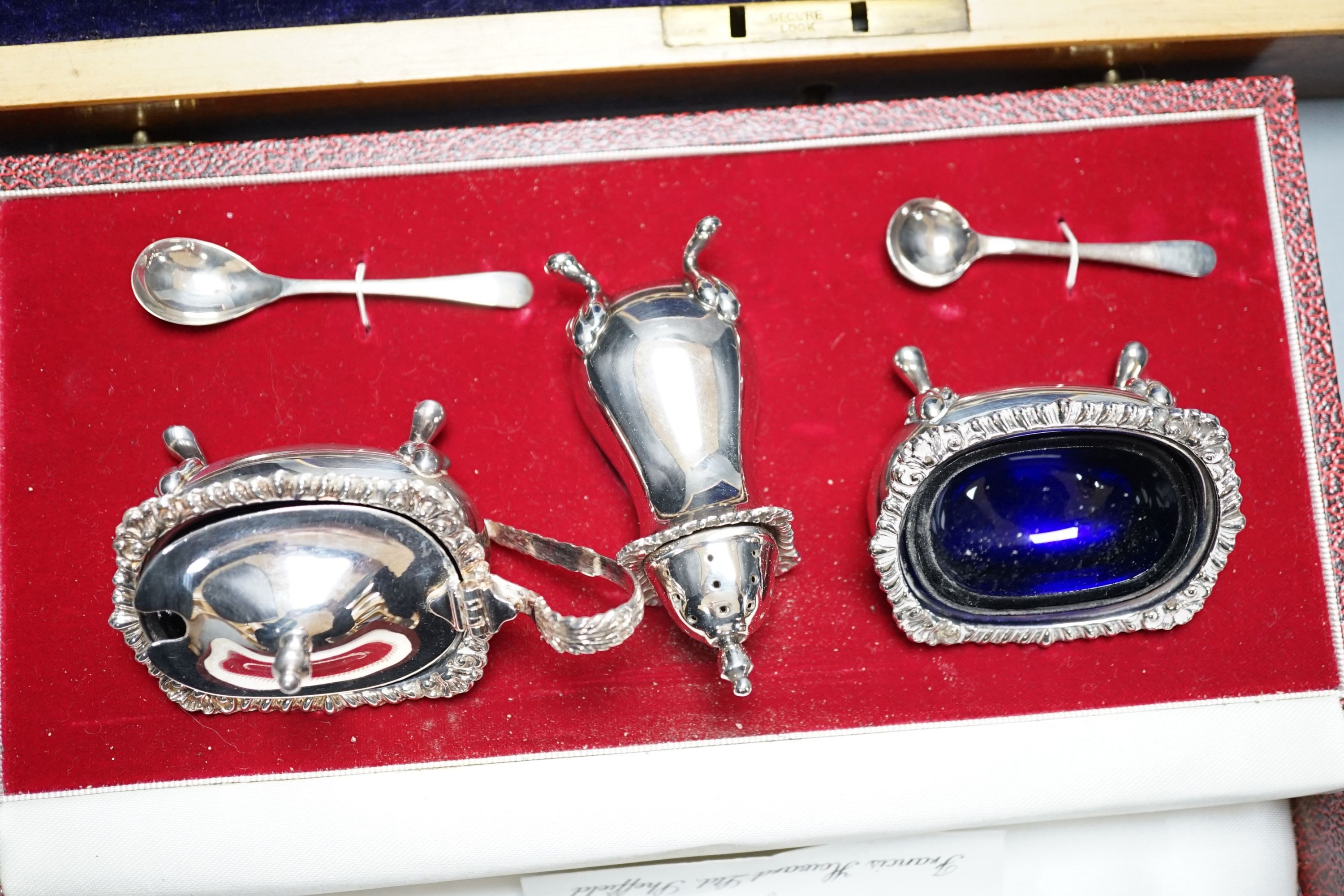 A cased modern silver three piece condiment set, a cased set of twelve Edwardian silver teaspoons, London, 1903 (lacking tongs) and two plated fish services.